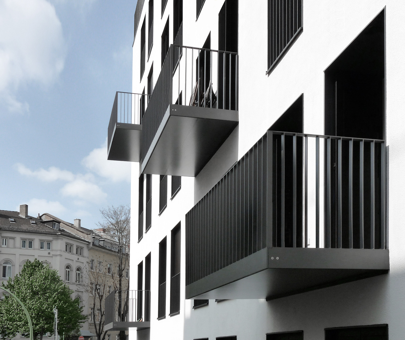 Das Bild zeigt eine Nahaufnahme der Fassade. Es wurde von unten hoch fotografiert, sodass die Unterkonstruktion der Balkone erkenntlich wird.